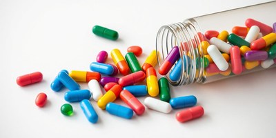 Colorful pills spill from a bottle