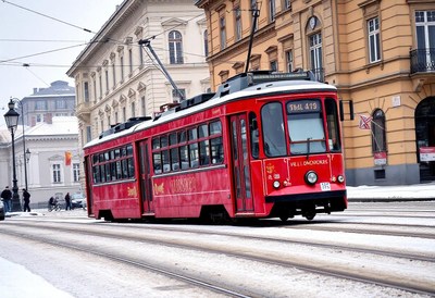 A red tram travels through a snowy city