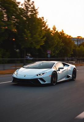 A white sports car drives down a city street at sunset