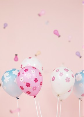Floral balloons float on a pink background