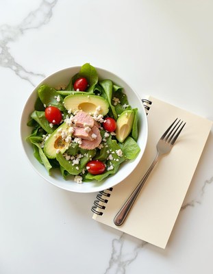 Fresh salad with avocado and cherry tomatoes on table