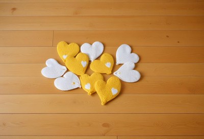 Heart-shaped knitted decorations on wooden floor
