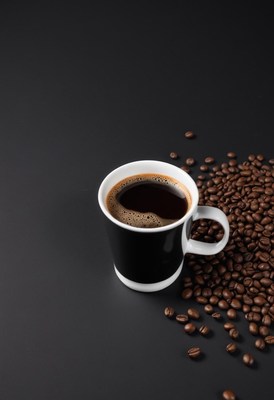 Freshly brewed coffee in a cup with coffee beans