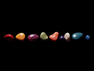 Colorful stones arranged in a line on a black surface
