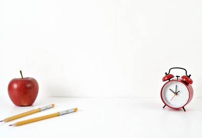 Red apple and alarm clock on a white background