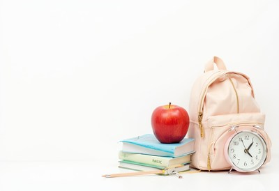 Backpack with books and apple on study desk
