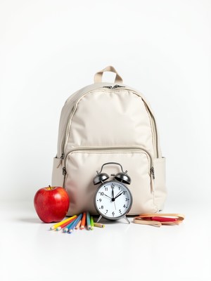 School supplies and alarm clock on white background