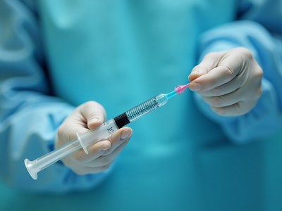 Surgical worker removes cap from syringe