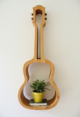 Unique guitar-shaped shelf holding plant and books