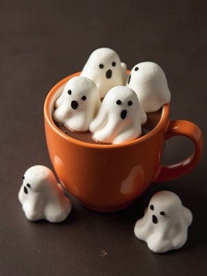 Whimsical ghost marshmallows float in hot chocolate