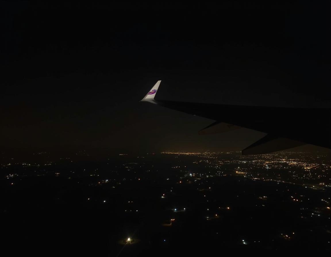 A plane wing and city lights at night A plane wing and city lights at night