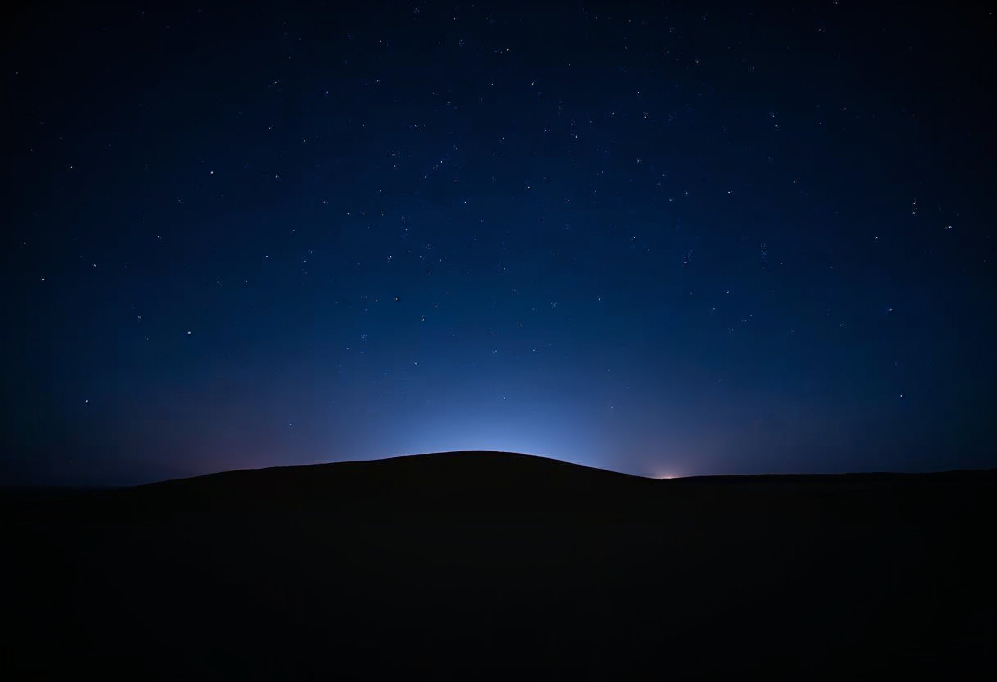 Night sky over a distant horizon illuminated by stars Night sky over a distant horizon illuminated by stars