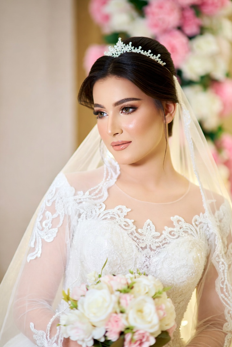 Bride in gown with bouquet against floral backdrop Bride in gown with bouquet against floral backdrop