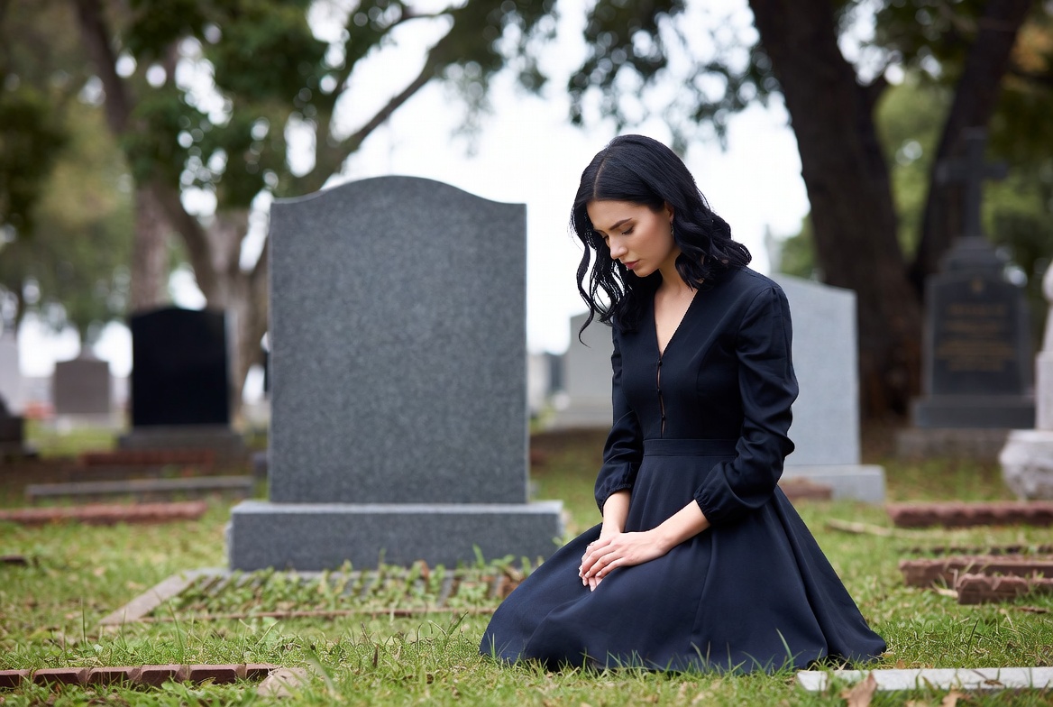 Woman at cemetery reflecting on loss Woman at cemetery reflecting on loss