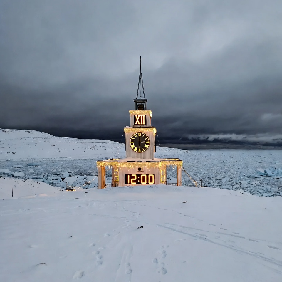 Clock tower in snowy landscape at noon Clock tower in snowy landscape at noon