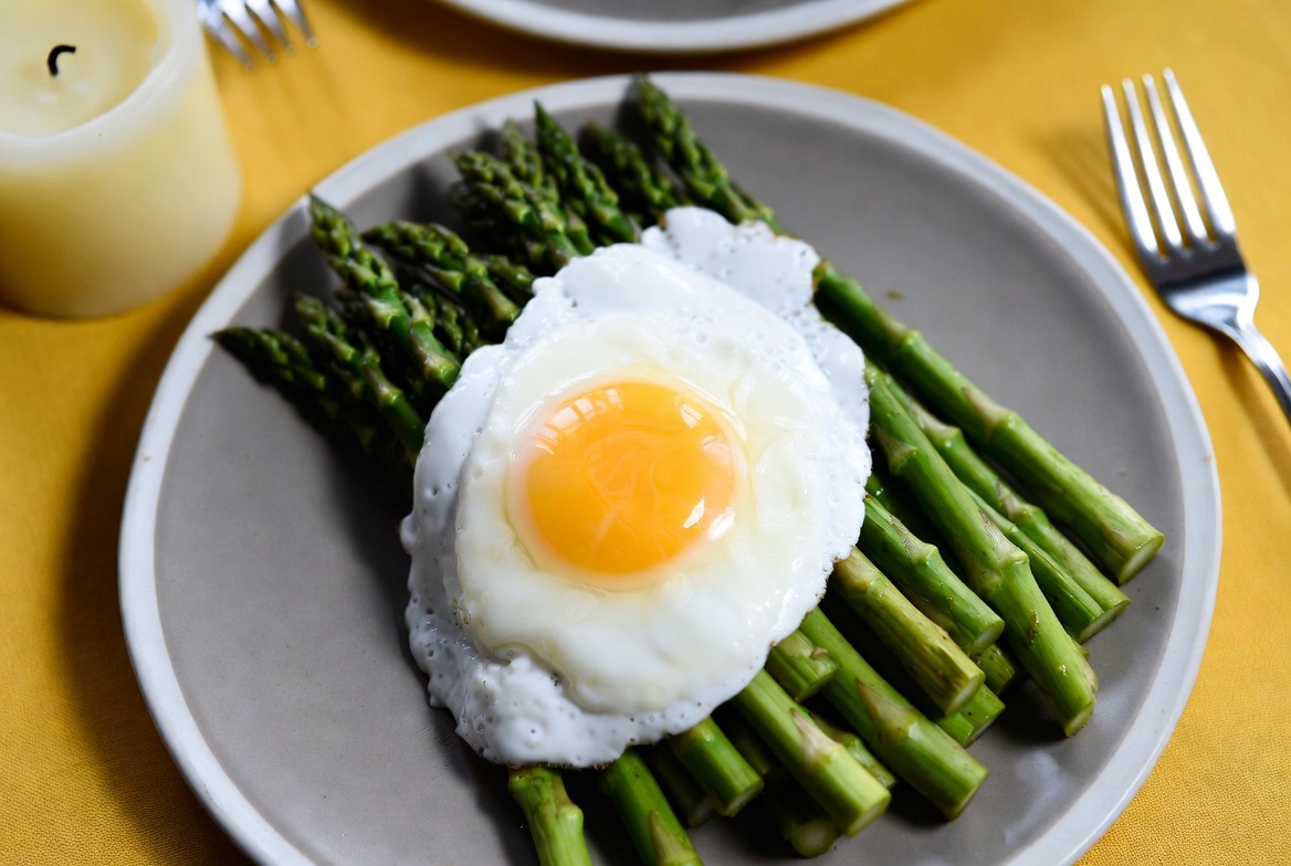 Egg on asparagus plate served at breakfast Egg on asparagus plate served at breakfast