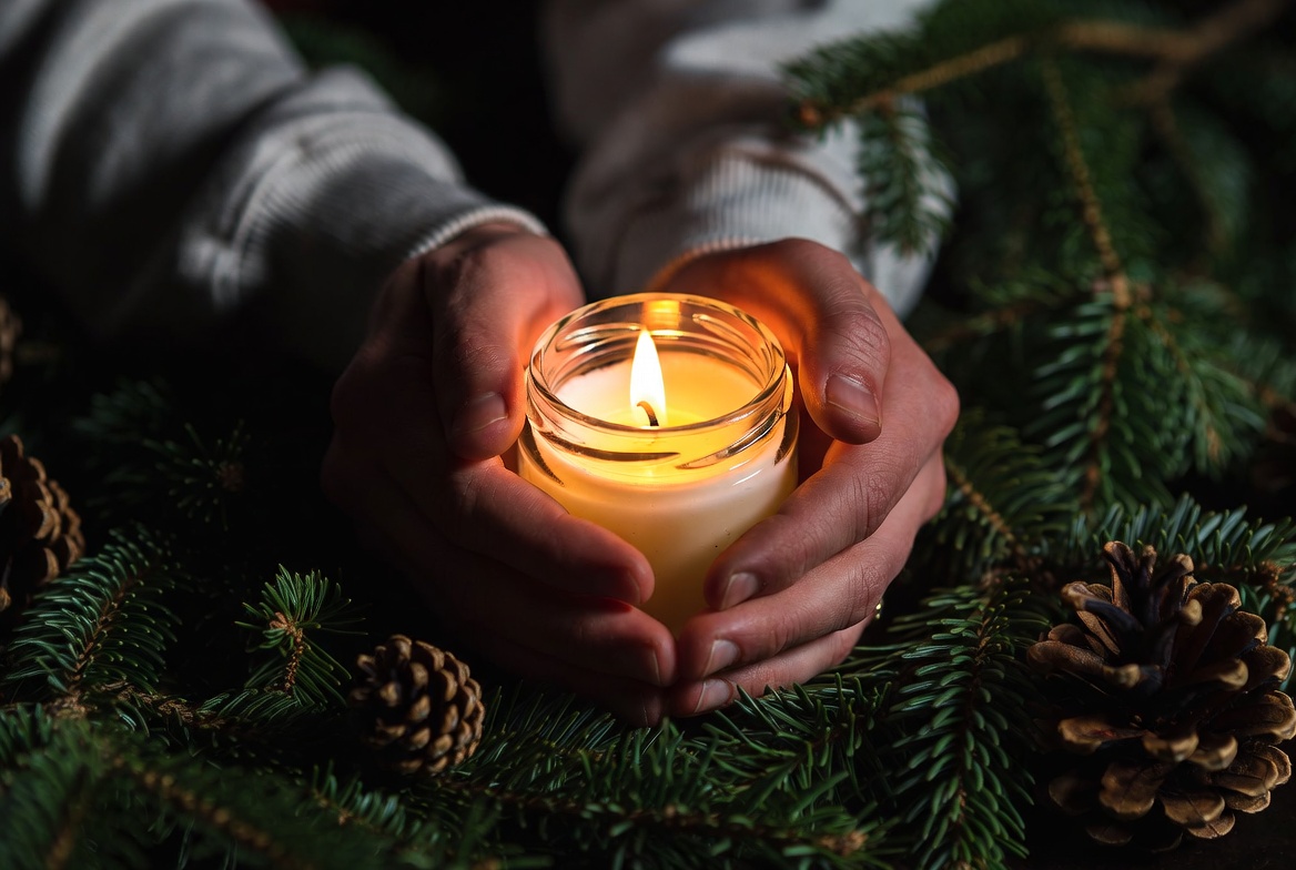 Hands holding candle in forest Hands holding candle in forest
