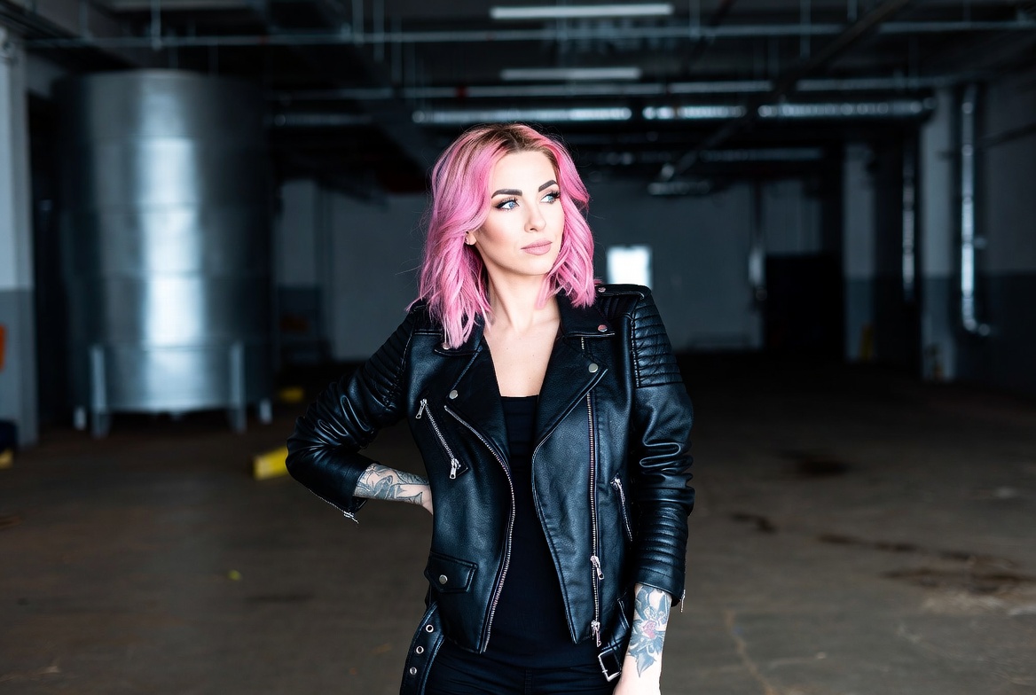 Woman in leather jacket poses indoors Woman in leather jacket poses indoors