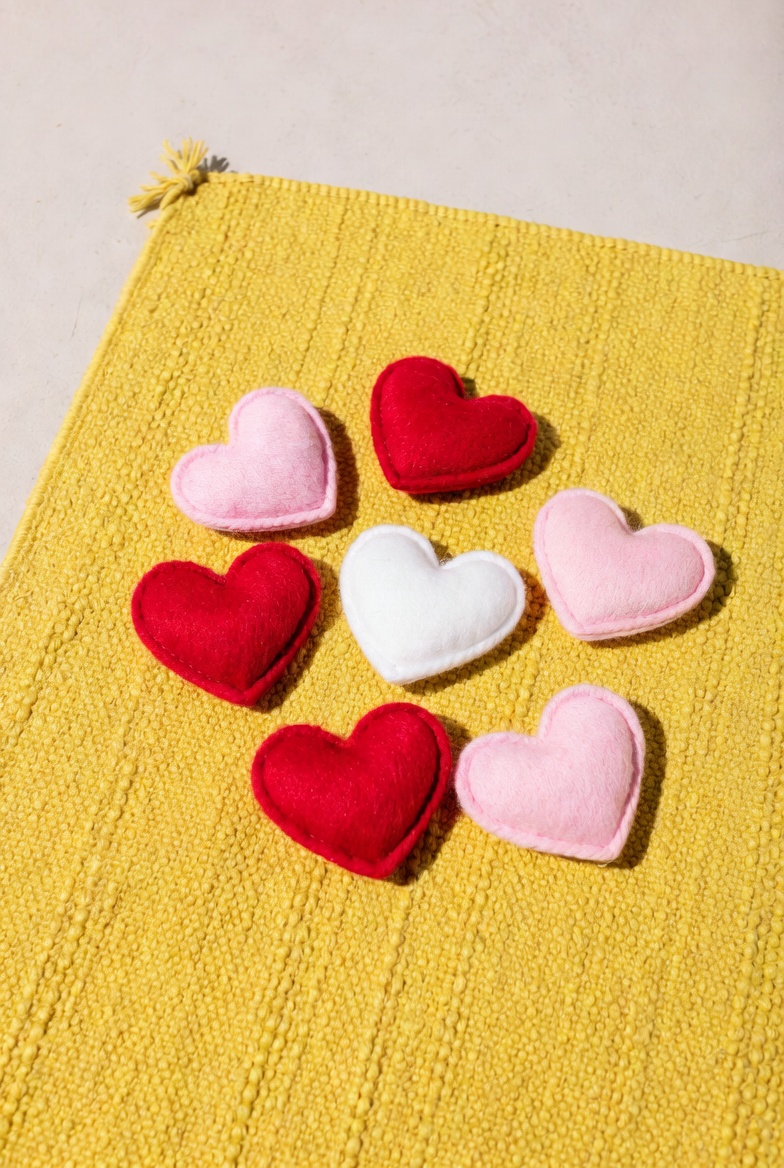 Colorful felt hearts on yellow mat Colorful felt hearts on yellow mat