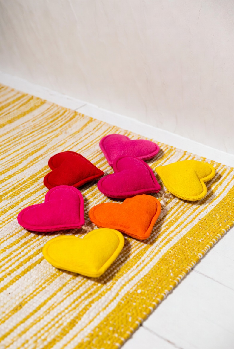 Colorful heart-shaped cushions on rug Colorful heart-shaped cushions on rug