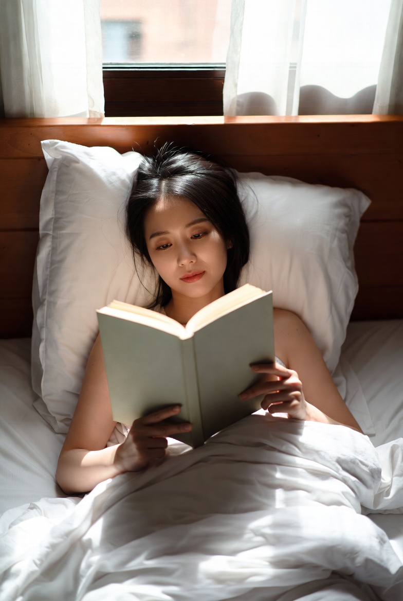 Asian woman reading book in bed Asian woman reading book in bed