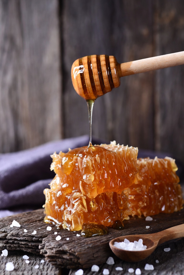 Honey dripping from wooden dipper Honey dripping from wooden dipper