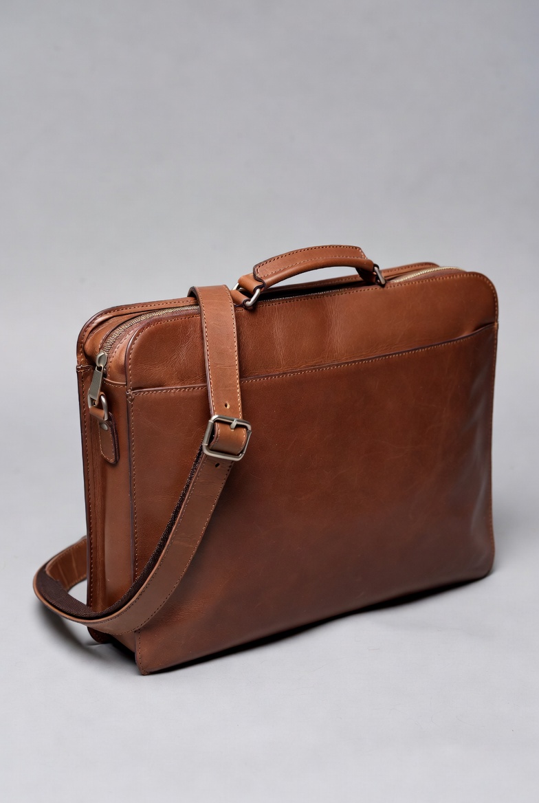 Brown leather bag on gray background Brown leather bag on gray background