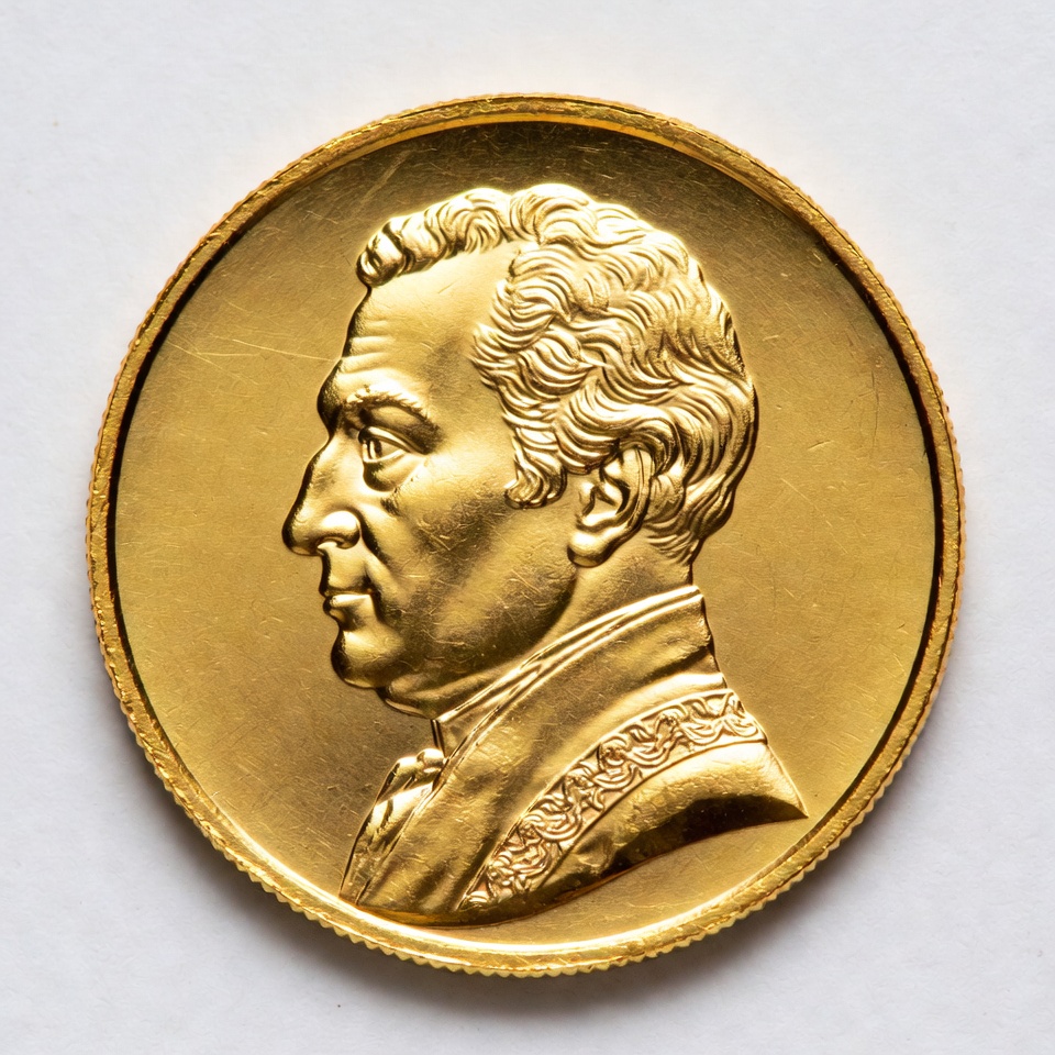 Gold coin with historical figure profile Gold coin with historical figure profile