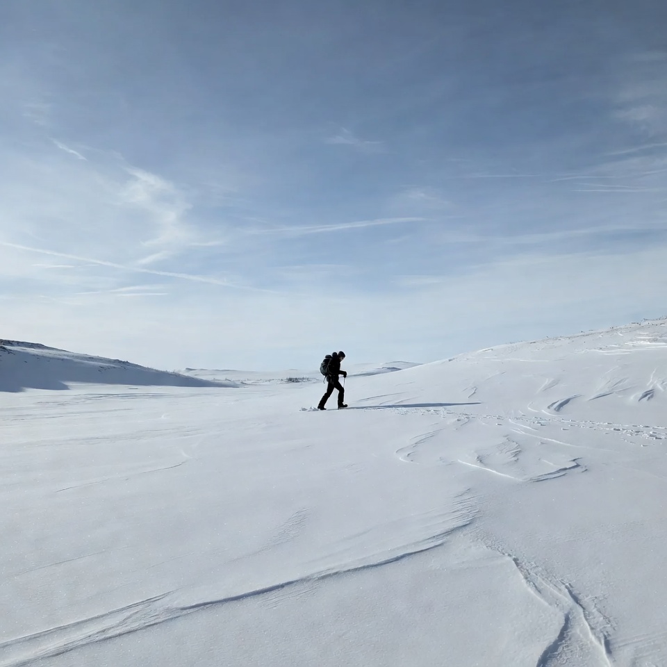 Hiker moving through snowy landscape Hiker moving through snowy landscape