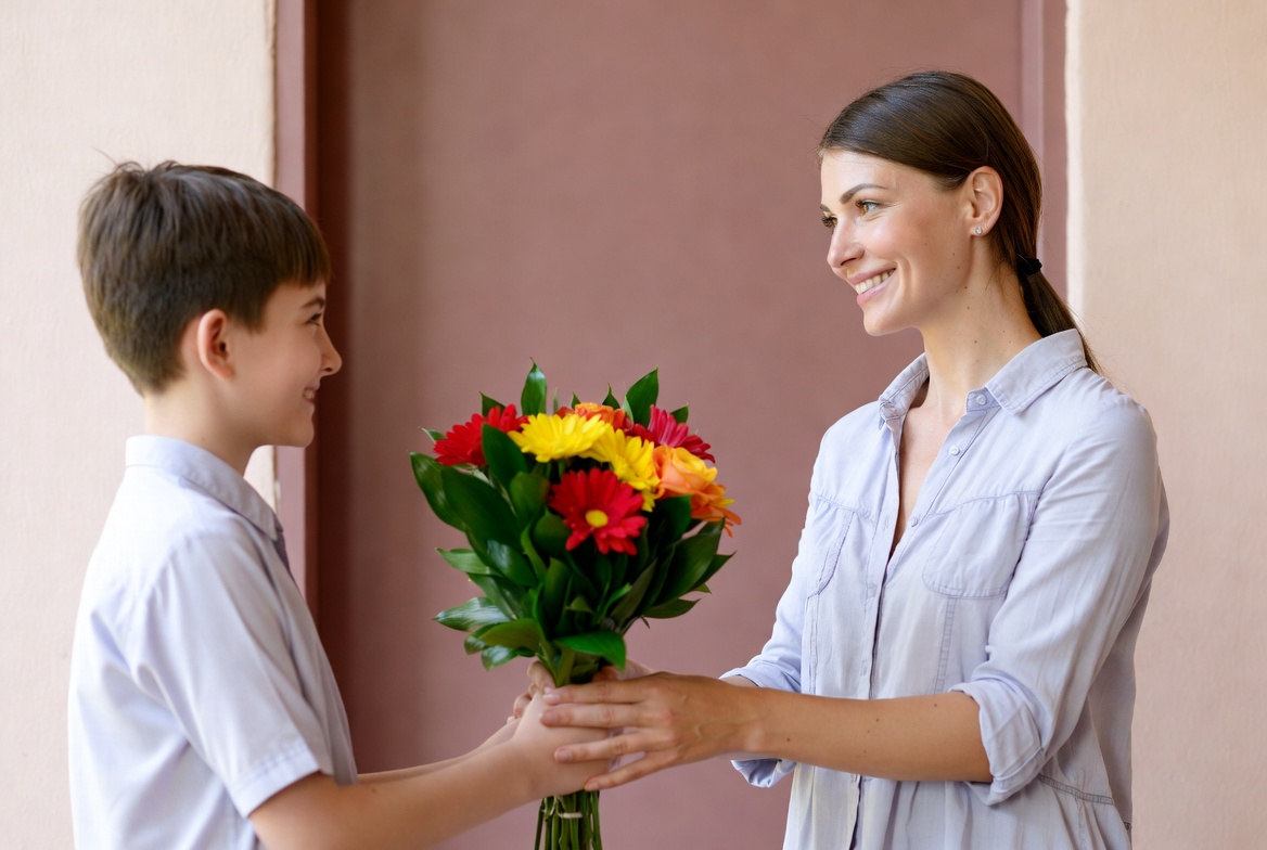 Boy gives flowers to woman Boy gives flowers to woman