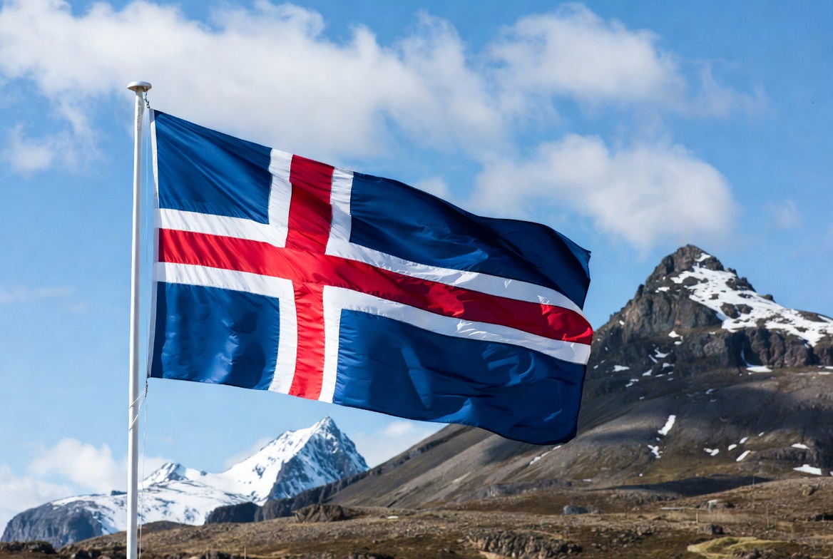 Iceland flag waving near mountains Iceland flag waving near mountains