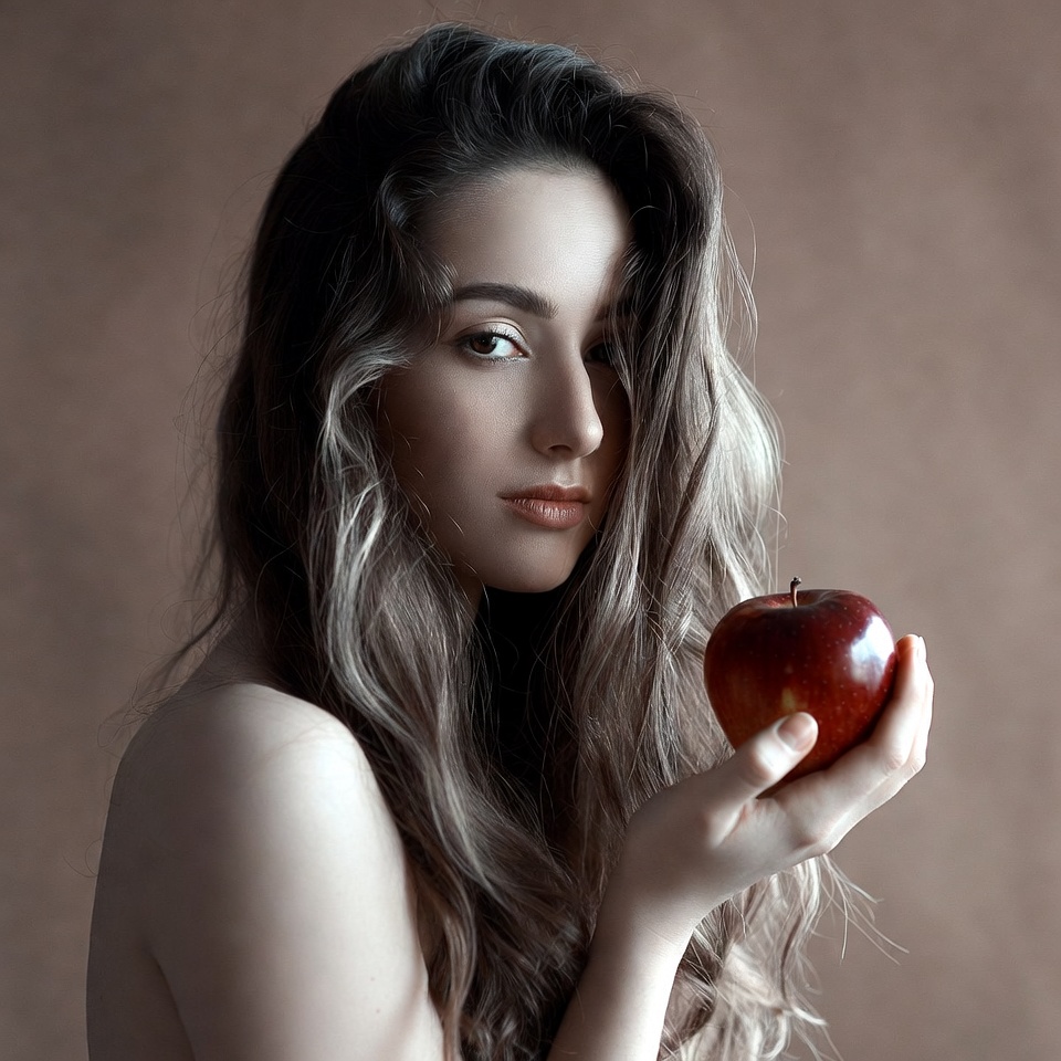 Woman holding red apple indoors Woman holding red apple indoors