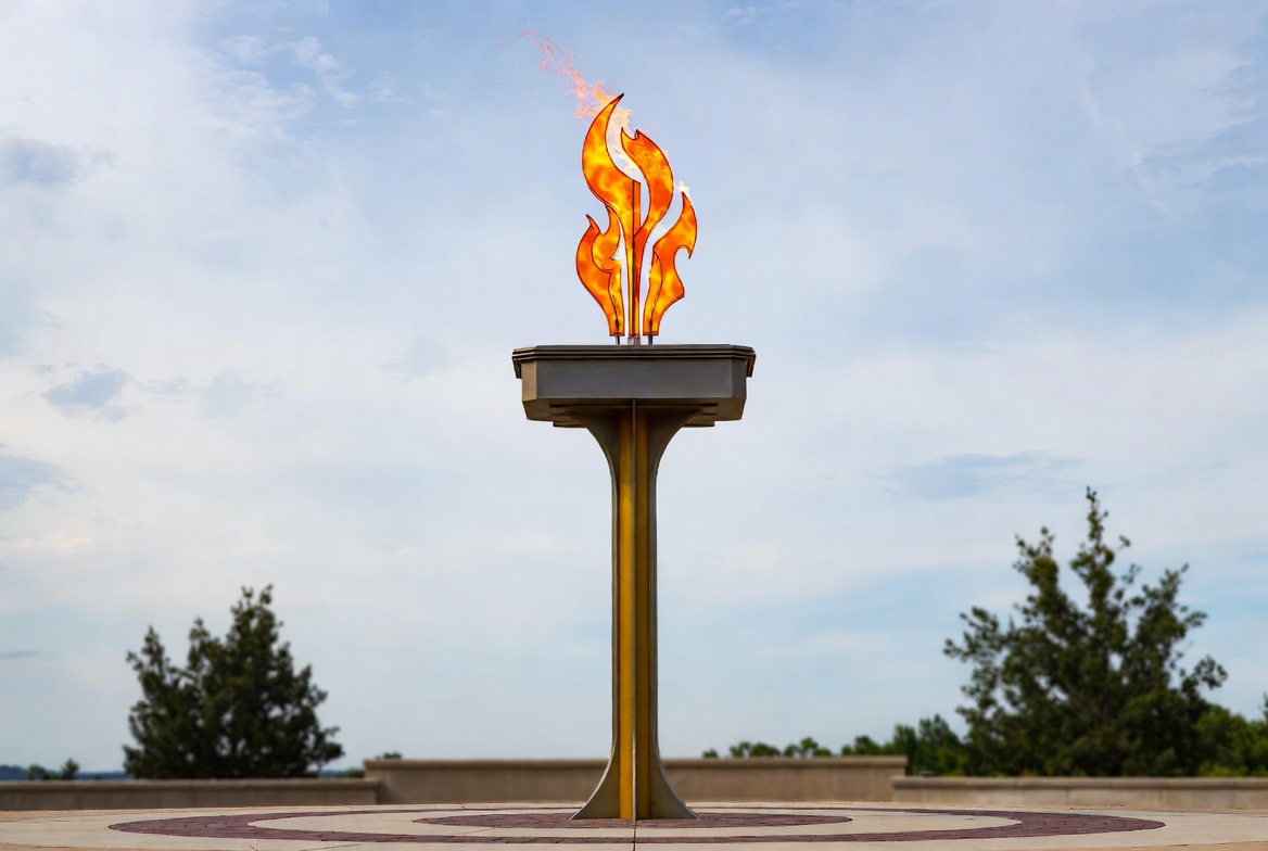 Olympic flame on tall pedestal during day Olympic flame on tall pedestal during day