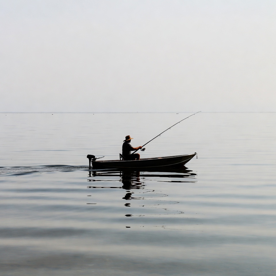 Fishing from a small boat on a calm lake Fishing from a small boat on a calm lake
