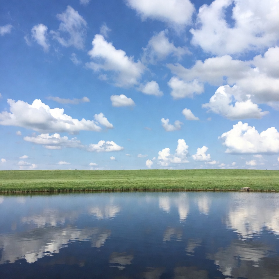 Calm water reflecting clouds on a sunny day Calm water reflecting clouds on a sunny day