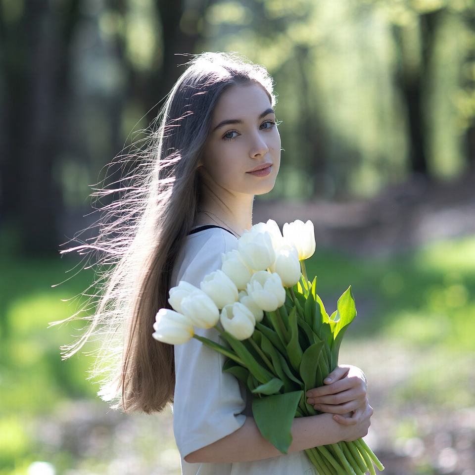 Young woman holding white tulips outdoors Young woman holding white tulips outdoors