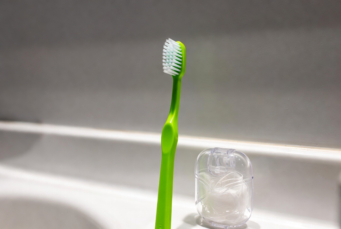 Green toothbrush on bathroom counter Green toothbrush on bathroom counter