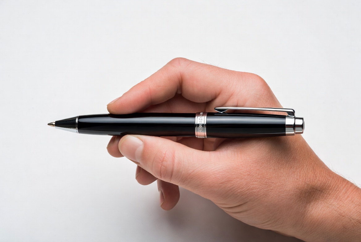 Hand holding a black pen Hand holding a black pen