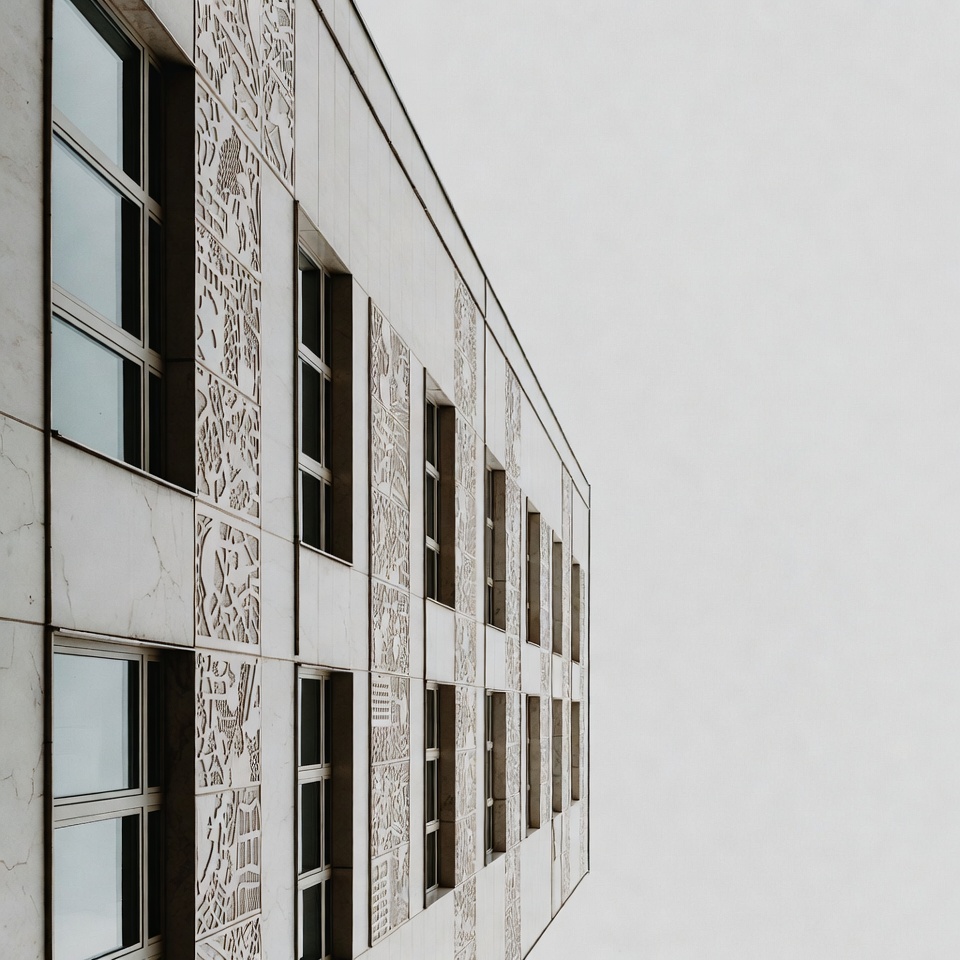 Building with patterned facade in cloudy sky Building with patterned facade in cloudy sky