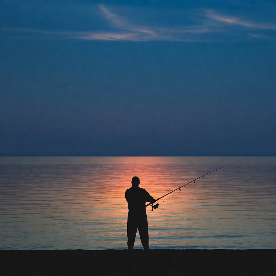 Man fishing at dusk by the water Man fishing at dusk by the water