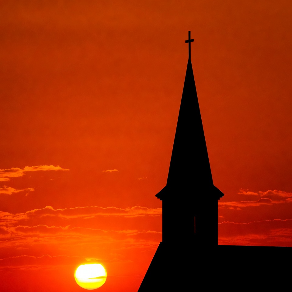 Sunset over church steeple silhouette Sunset over church steeple silhouette