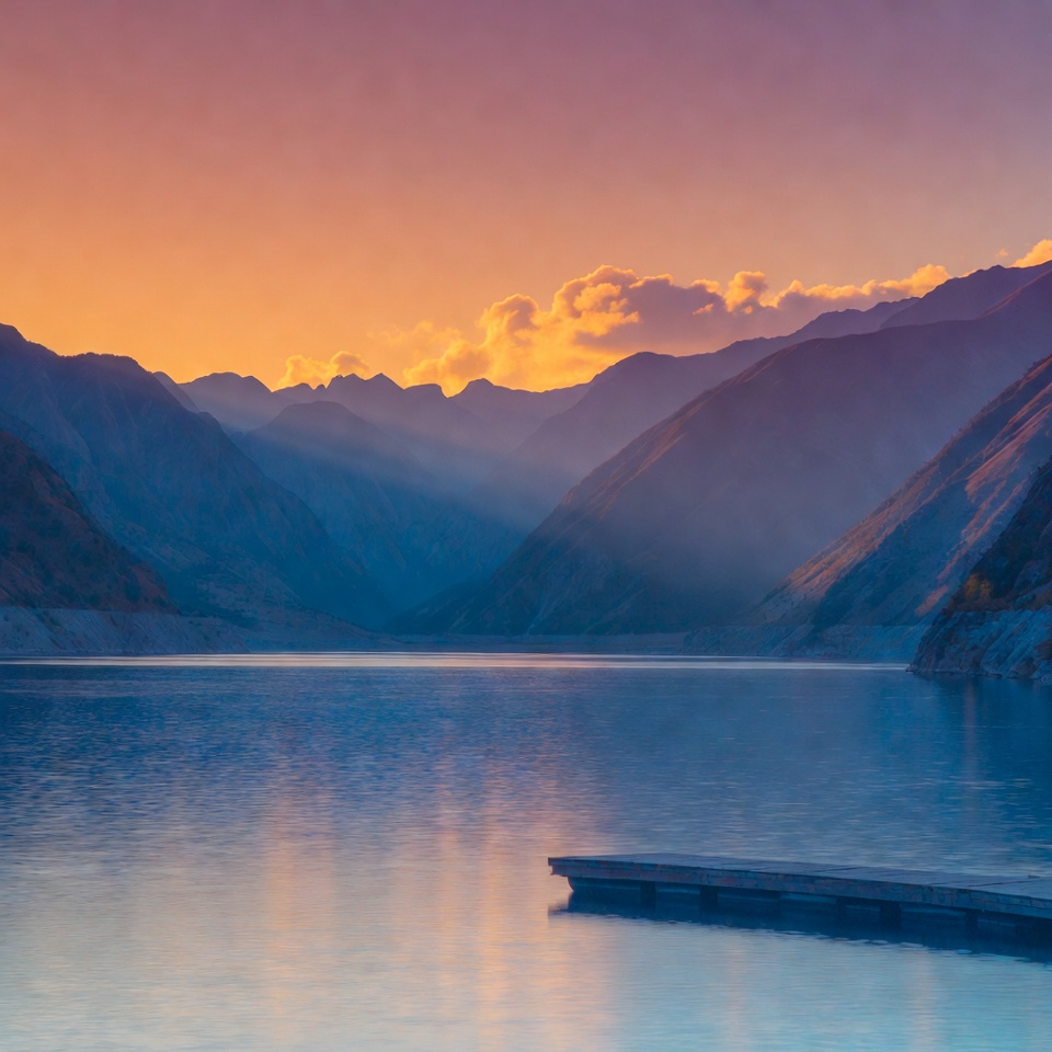 Mountains reflect in calm water at sunset Mountains reflect in calm water at sunset