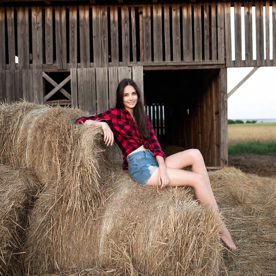 Girl sitting on hay bales at farm Girl sitting on hay bales at farm