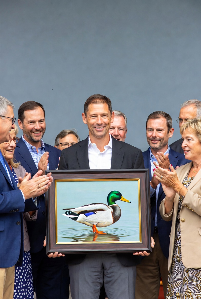 Man holding duck painting with group Man holding duck painting with group