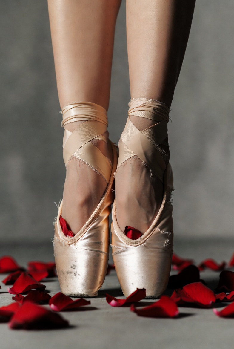 Ballerina's pointe shoes with red rose petals Ballerina's pointe shoes with red rose petals