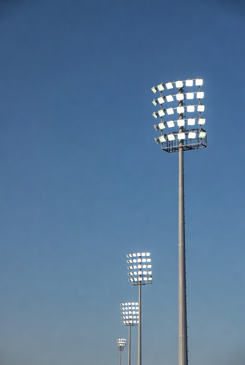Floodlights on Poles Against Blue Sky Floodlights on Poles Against Blue Sky
