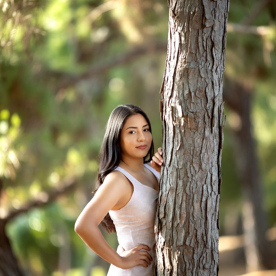 Latina woman leaning against tree Latina woman leaning against tree