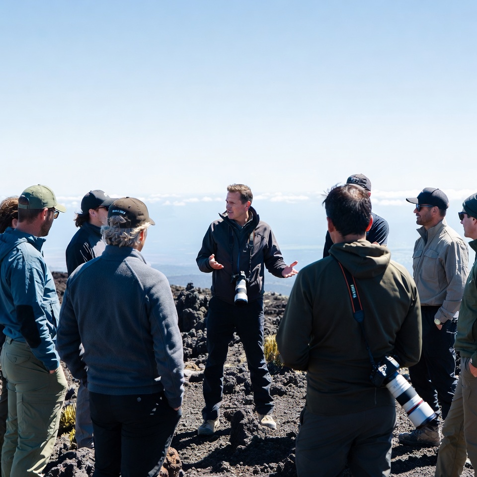 Group of men discussing on volcano Group of men discussing on volcano