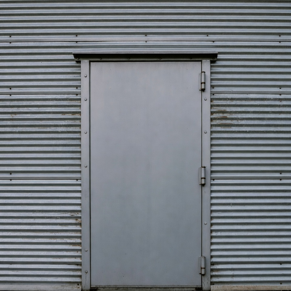Gray Metal Door on Corrugated Wall Gray Metal Door on Corrugated Wall