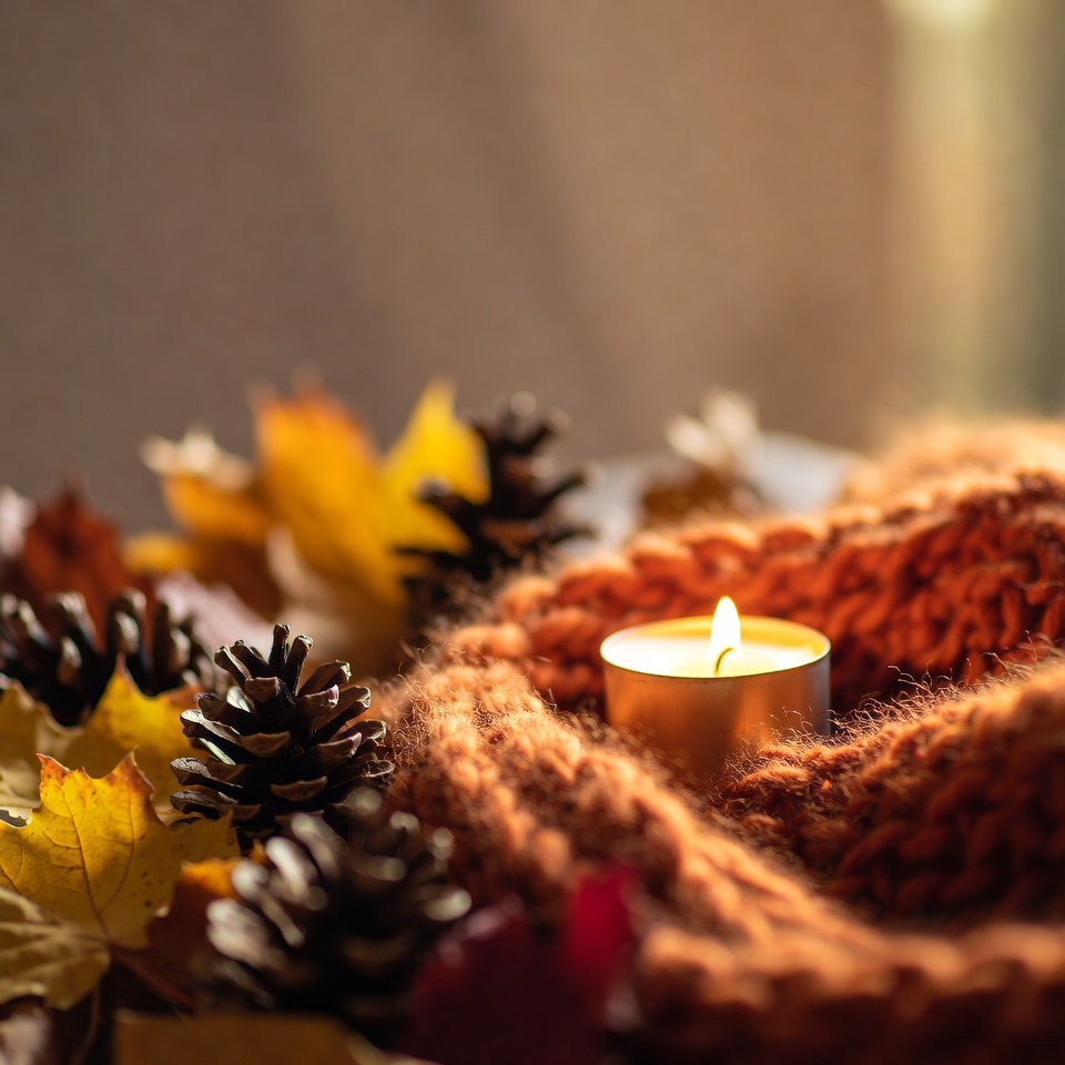Lit Candle with Autumn Leaves and Pine Cones Lit Candle with Autumn Leaves and Pine Cones